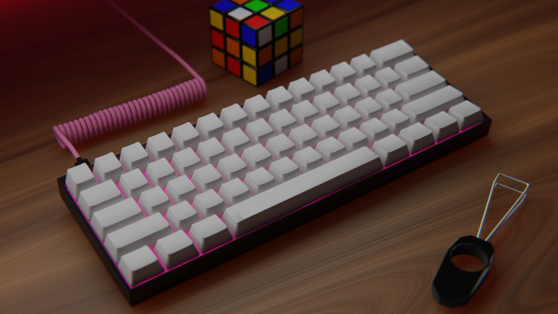 Tastiera 60% con keycaps bianchi, scocca nera e led rosa. Dietro la tastiera un cubo di Rubik non risolto e davanti la tastiera un keycaps puller. I keycaps sono vuoti. Il cavo della tastiera è a spirale ed è rosa. Il tavolo della scrivania è di legno. La lampadina qua è spenta